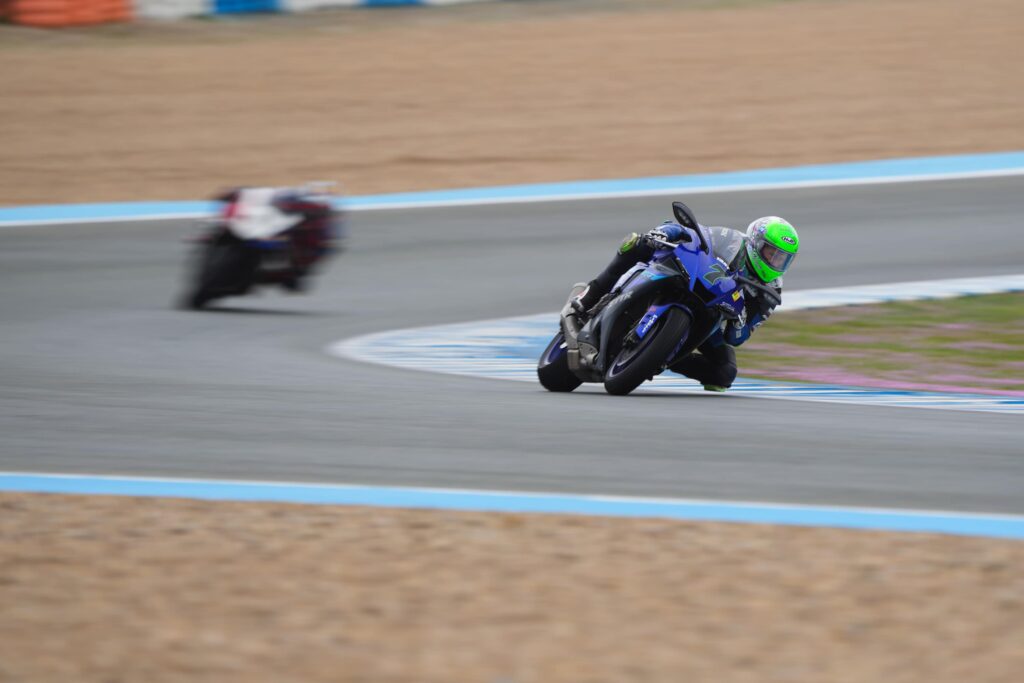 two motorcycle racers on track leaned into the apex
