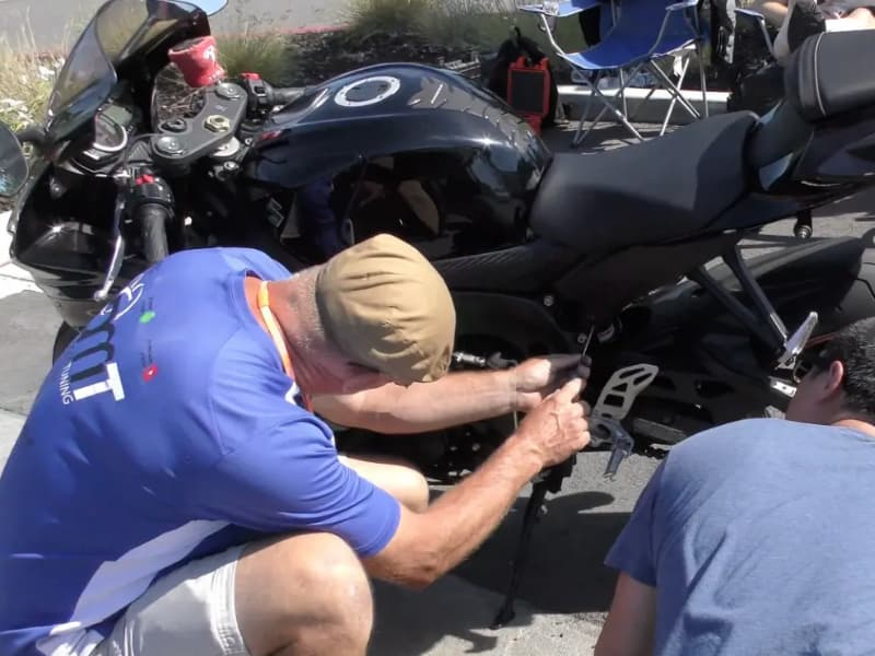 A man is adjusting the Motorcycle shock