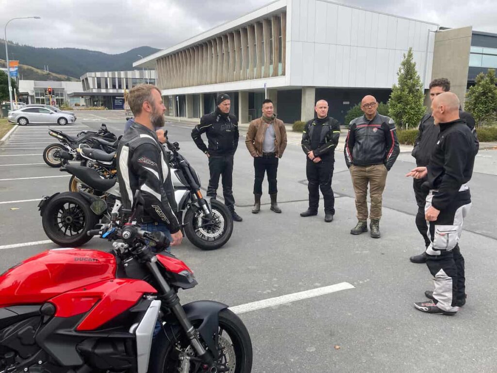 A group of Motorcycle riders standing in a circle