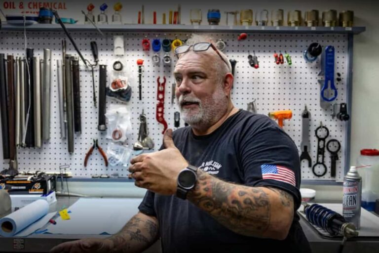 a man standing in from of a suspension station and talking