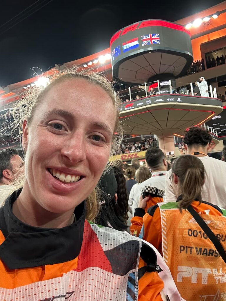 A track marshal is standing under the podium at the F1 Grand Prix