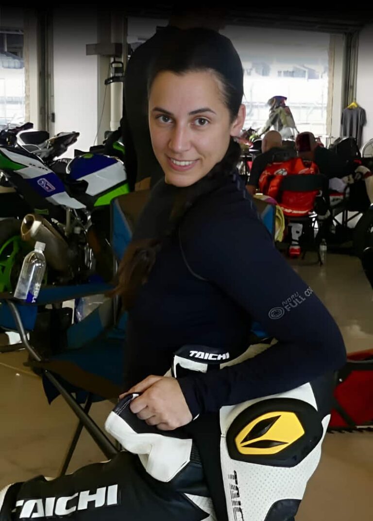 a woman in her racing leather suit looking at the camera