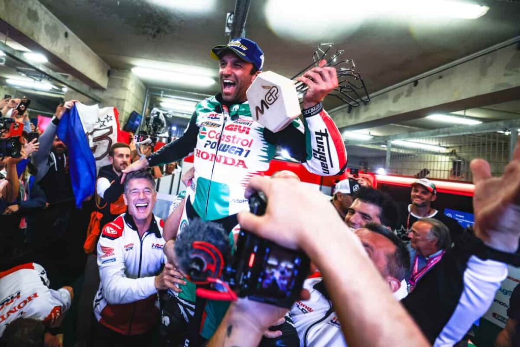 a motorcycle racer and his team is celebrating the win