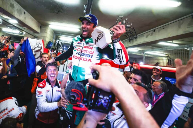 a motorcycle racer and his team is celebrating the win