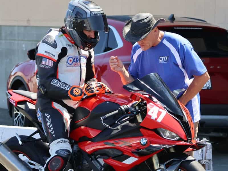 A man adjusting the motorcycle suspension