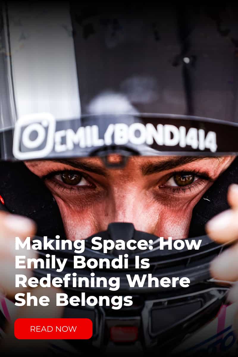 a woman in a racing motorcycle helmet looking at the camera