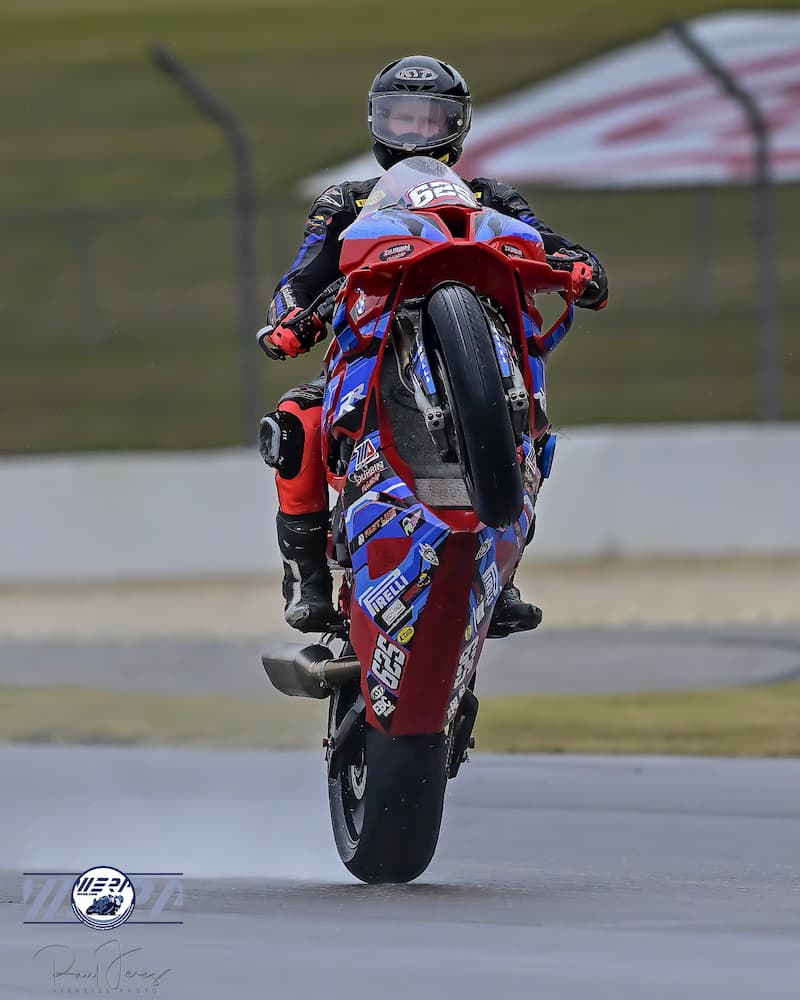 a motorcycle racer is wheeling in rain