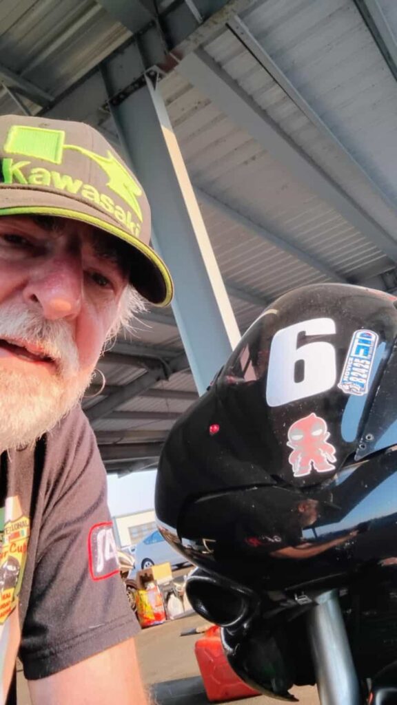 A man sitting next to his bike looking at the camera