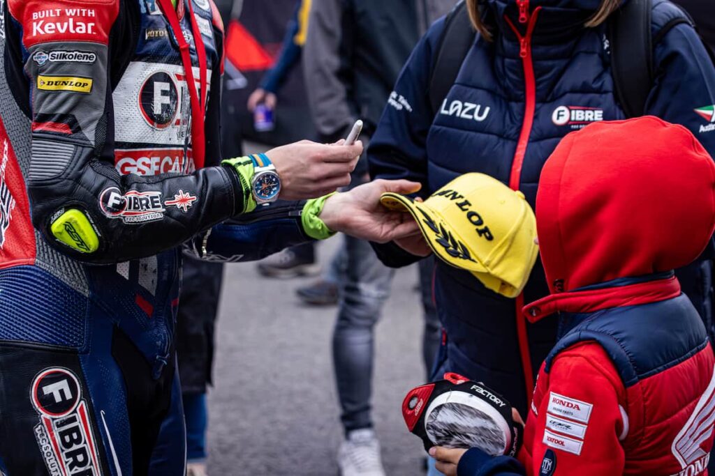 a racer singing a race fan's hat