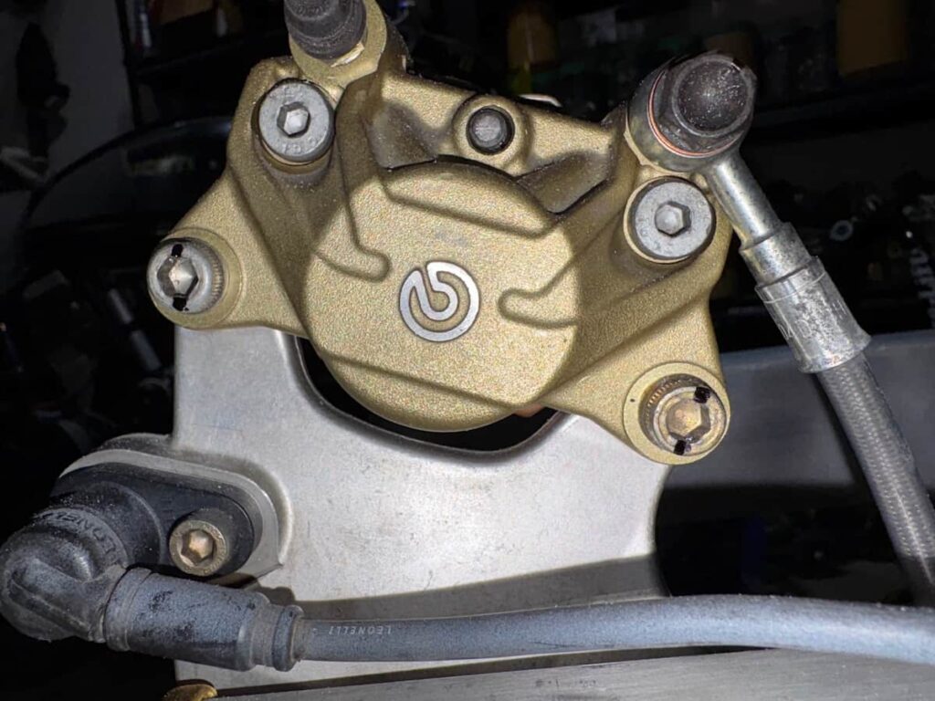 Motorcycle brake caliper, mounted, and prepped for drills for safety wires