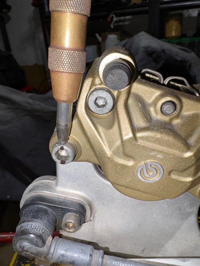 Demonstrating the places of trails on the motorcycle brake caliper bolts