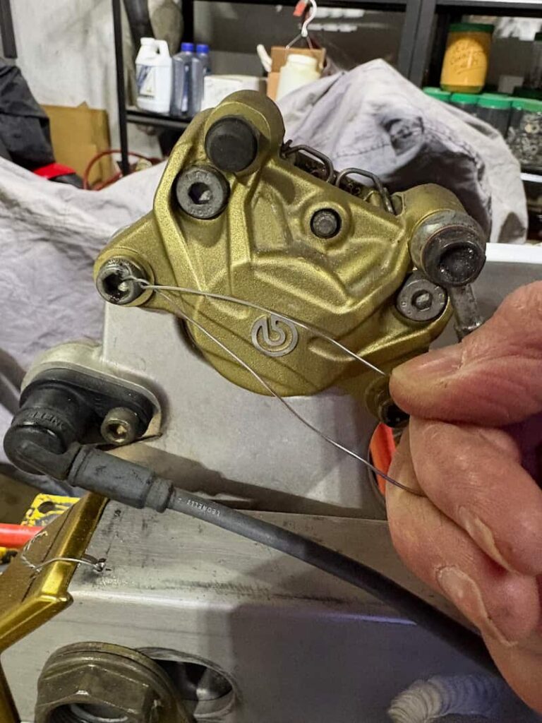 Motorcycle brake caliper is being safety wired