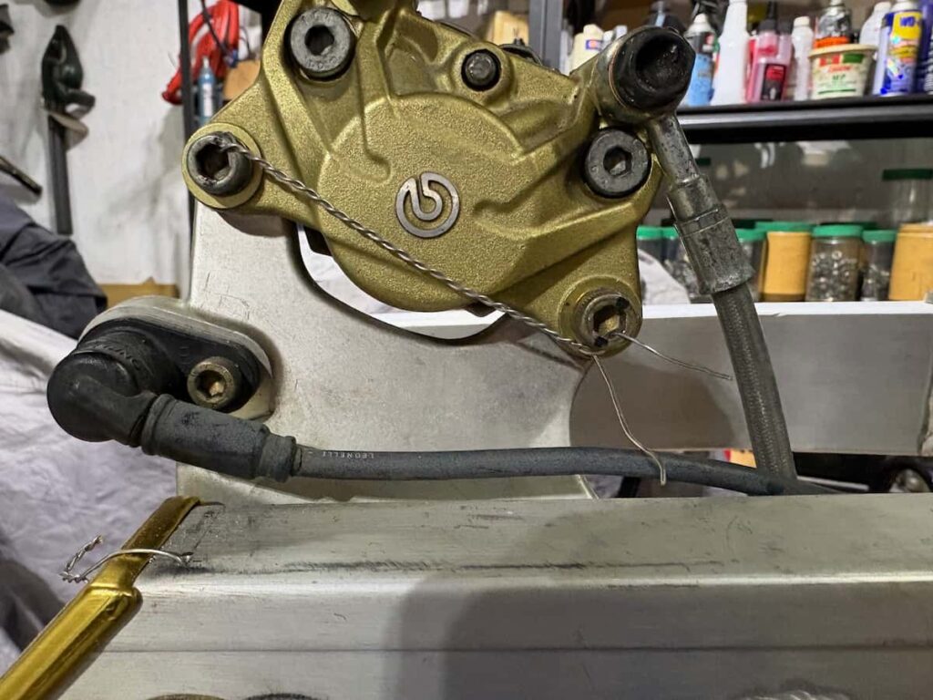 Motorcycle brake caliper is being safety wired