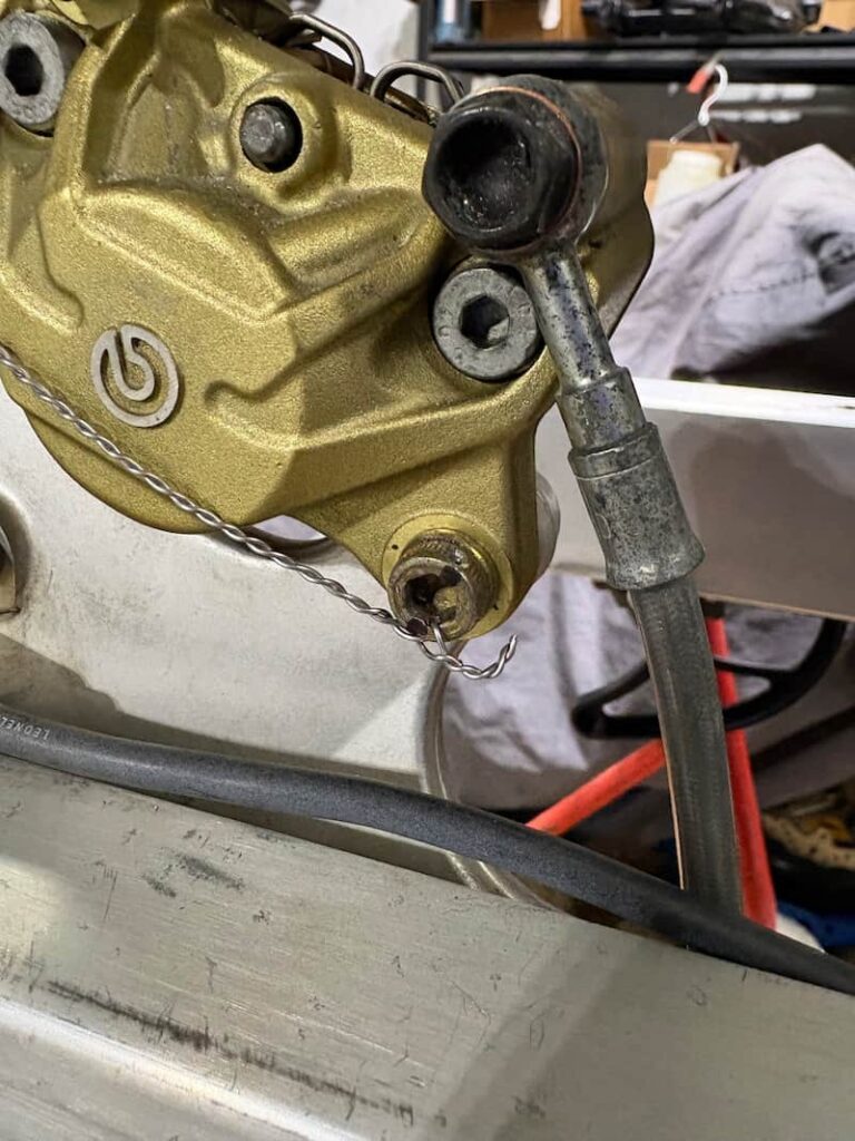 Motorcycle brake caliper is being safety wired