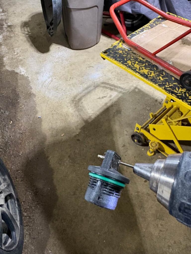 What motorcycle engine oil cap being drilled out for safety wires