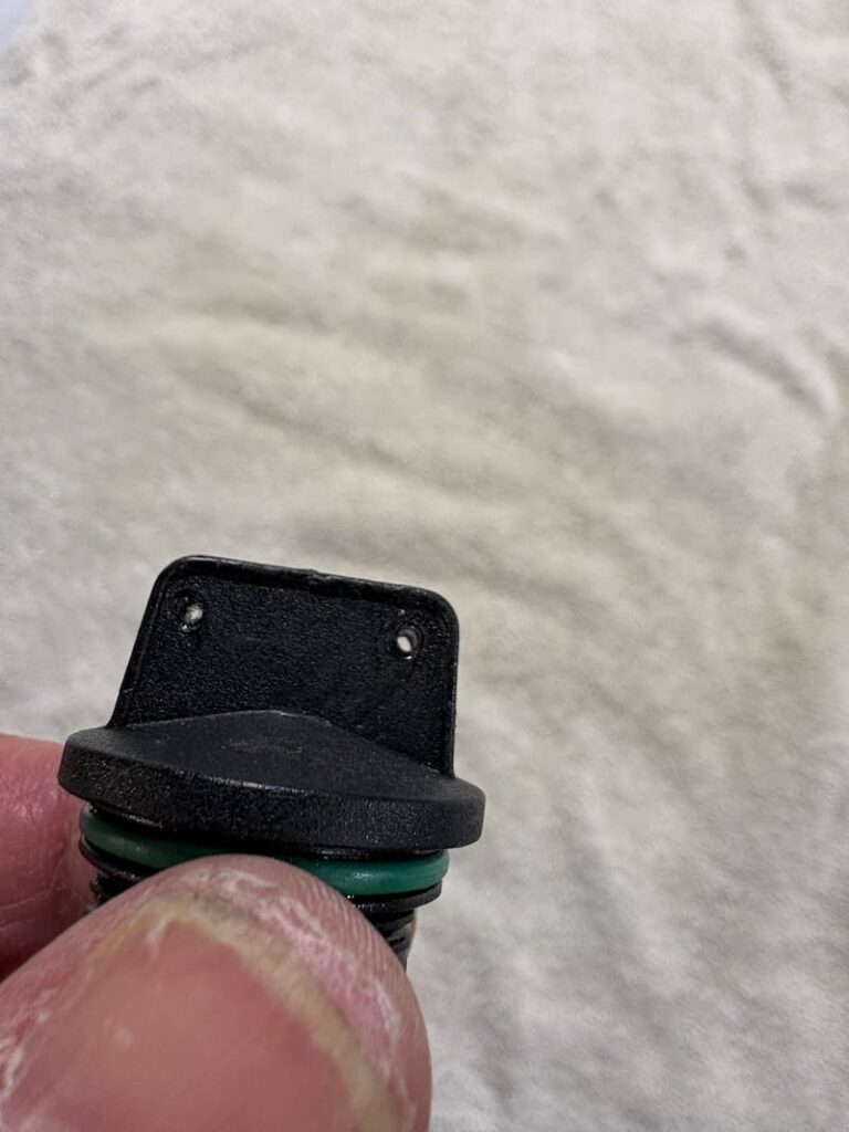 This photo of demonstrates the engine oil filling cap with two holes for safety wires