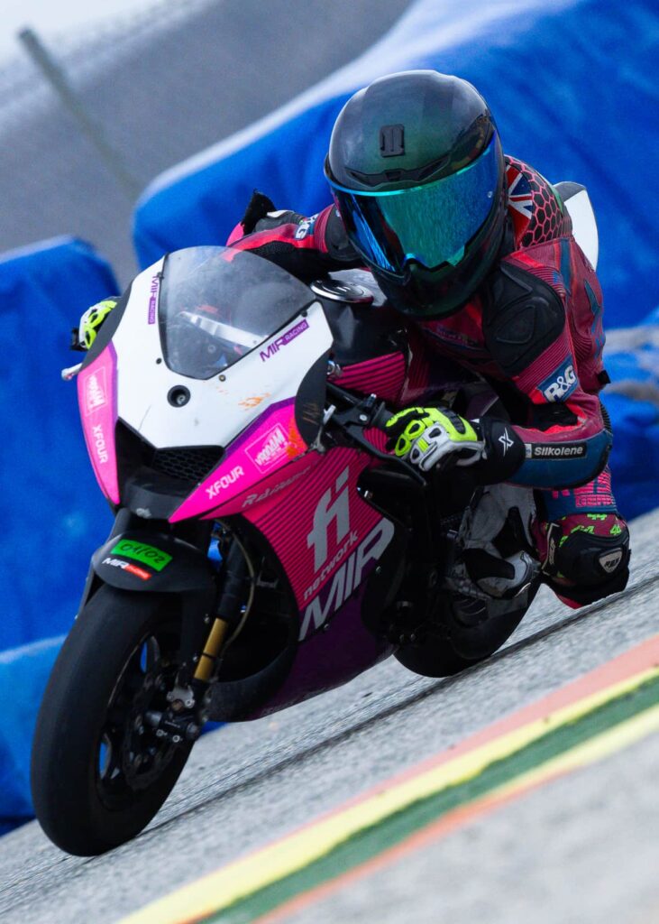 a kid on a race motorcycle leaned with her knee down