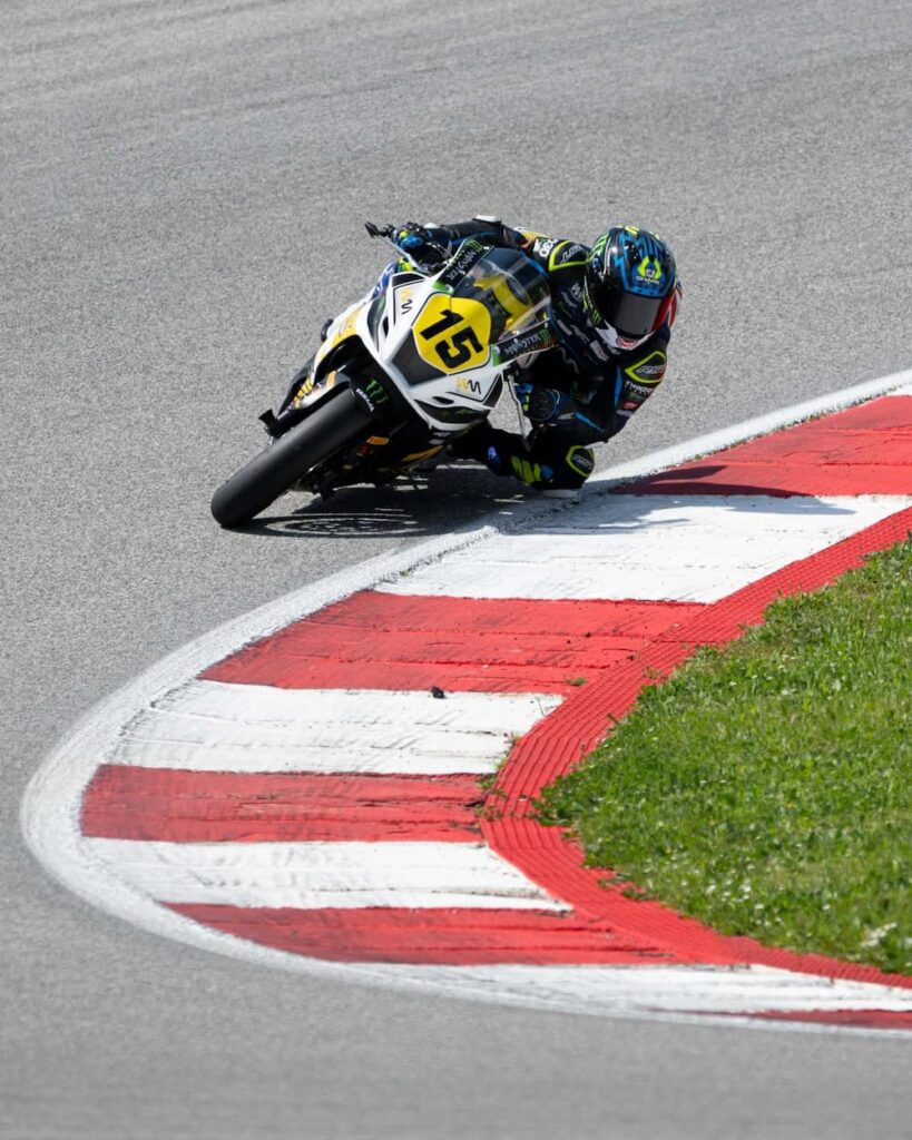 a motorcycle races at the apex