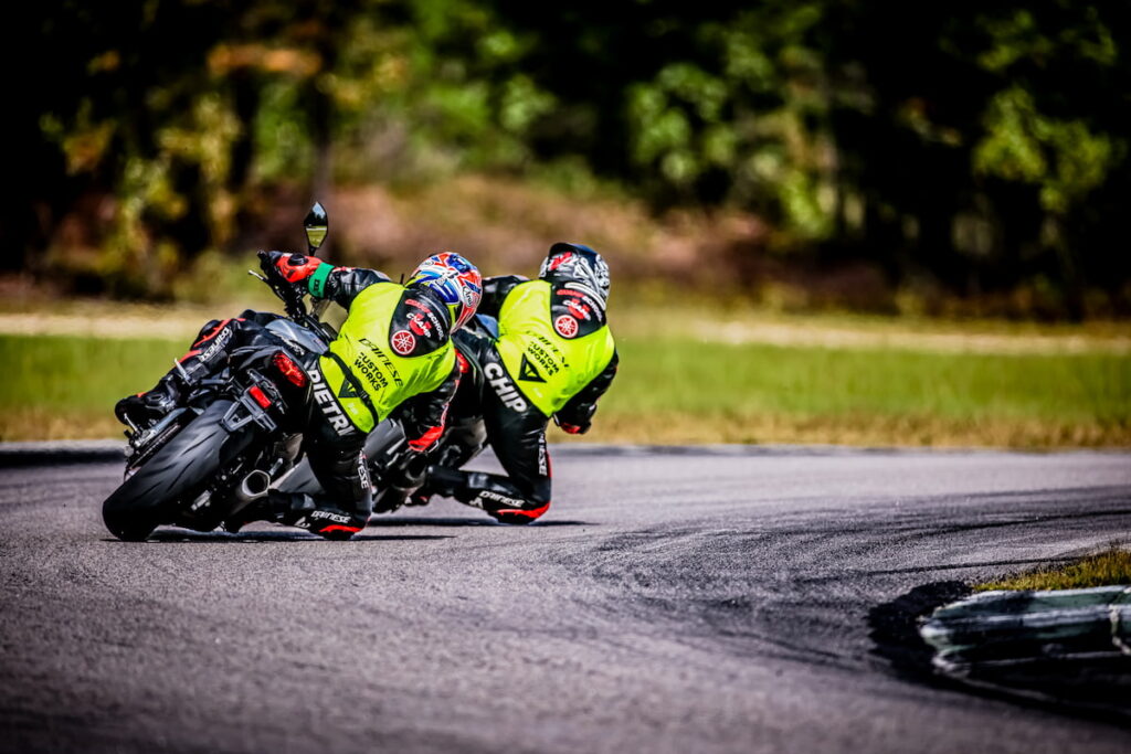 2 motorcycle racers on track leaned into the apex