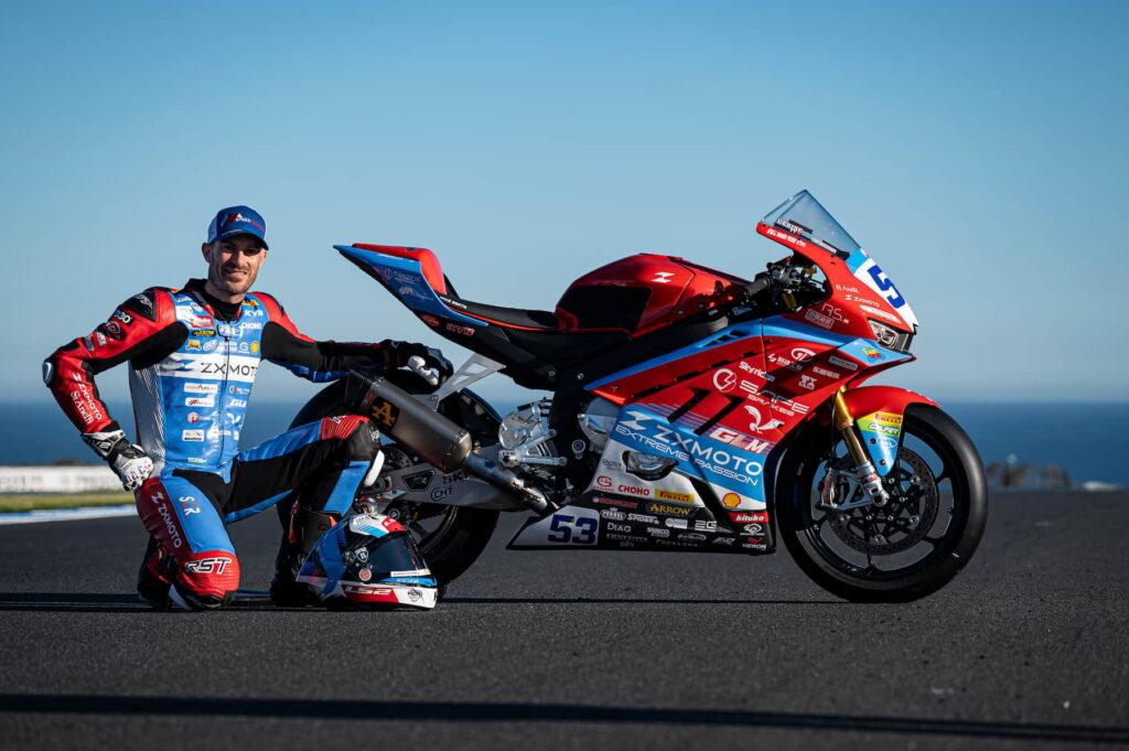 a racer next to his superbike on the track