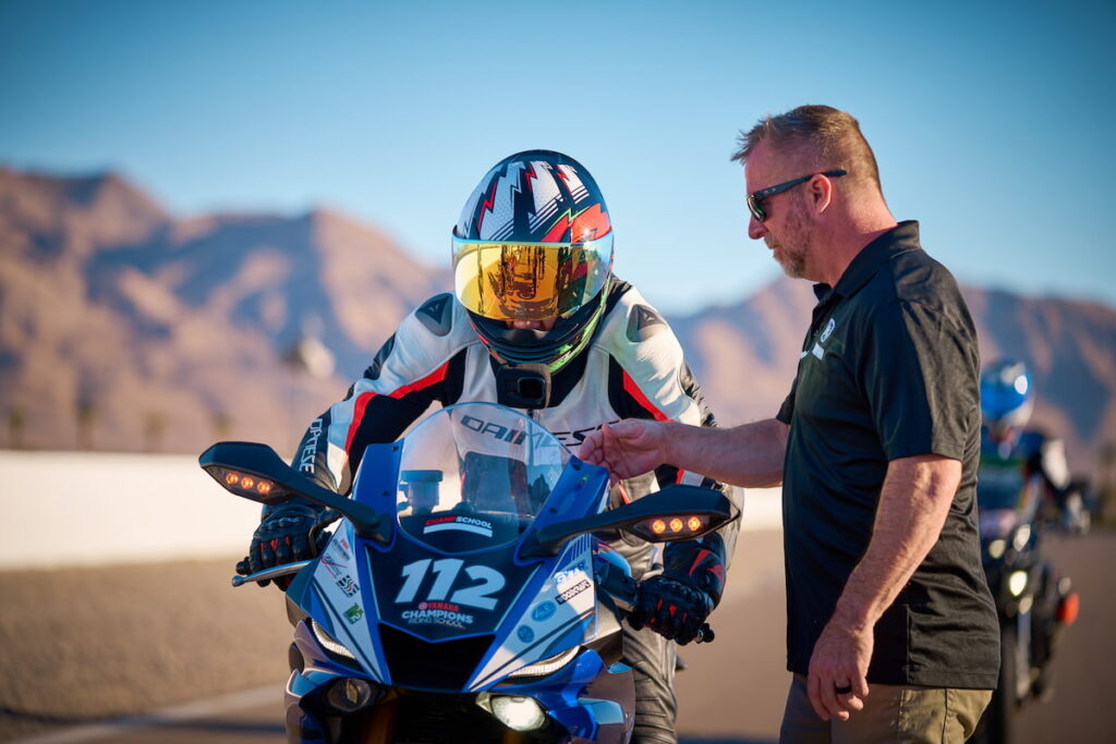 a motorcycle coach talking to a racer